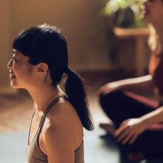 A woman trying mat Pilates in a studio with a friend