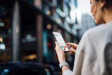 Woman looking at stock market on her phone