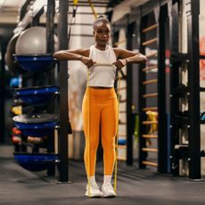 A woman doing one of her favourite resistance band arm workouts at home