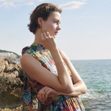 Model wearing a floral dress sold at Liberty London by the sea