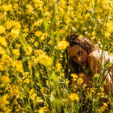 Solar perfumes: a woman in a yellow flower field under the sun