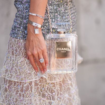 Woman wearing classic perfume bag Chanel No5 bottle handbag