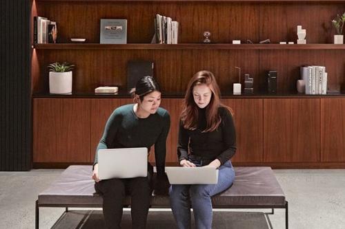 Two people sitting with laptops